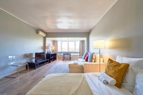 BEACHFRONT Cascais,Estoril Apartment في استوريل: غرفة نوم مع سرير وغرفة معيشة
