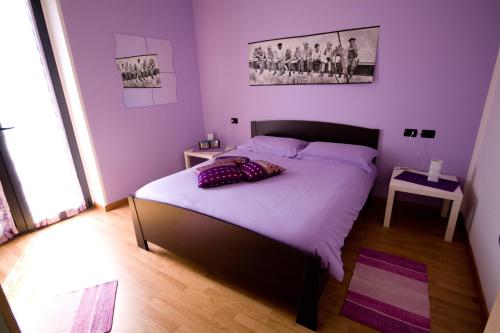 a bedroom with a large bed with purple walls at Casa Vacanze Zia Vivina B N in Sorico