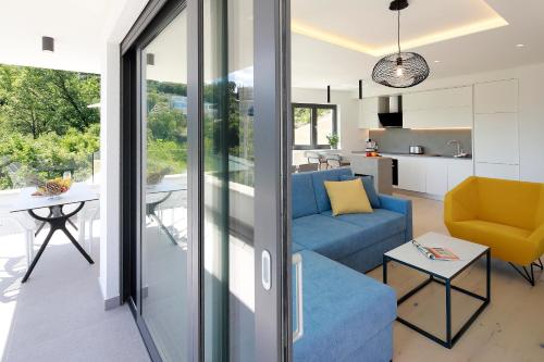a living room with a blue couch and a kitchen at MODENA MARIS-heated pool-grill-relax-jacuzzi apartments in Ičići