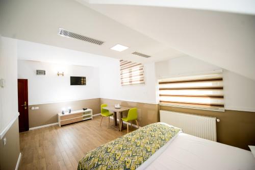 a bedroom with a bed and a table in it at Hotel Mariko Inn in Roman