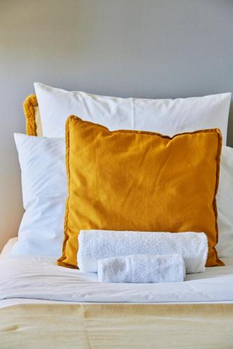 a bed with a yellow pillow and two towels at BEACHFRONT Cascais,Estoril Apartment in Estoril