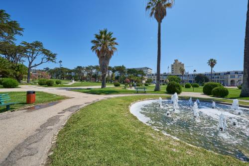 a fountain in a park with palm trees at BEACHFRONT Cascais,Estoril Apartment in Estoril