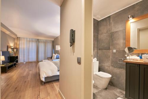 エストリルにあるCascais-Estoril BEACHFRONT Apartmentsのベッドとバスルーム付きのホテルルームです。