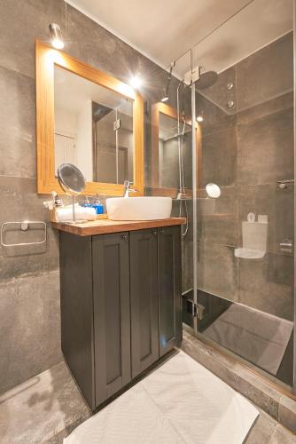 a bathroom with a sink and a mirror and a shower at Cascais-Estoril BEACHFRONT Apartments in Estoril