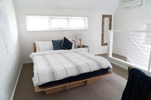 a white bedroom with a bed with a window at Gawler Townhouse 1 Bedroom in Gawler