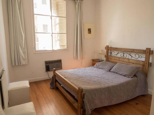 Un dormitorio con una cama grande y una ventana en Silencioso departamento antiguo en Buenos Aires