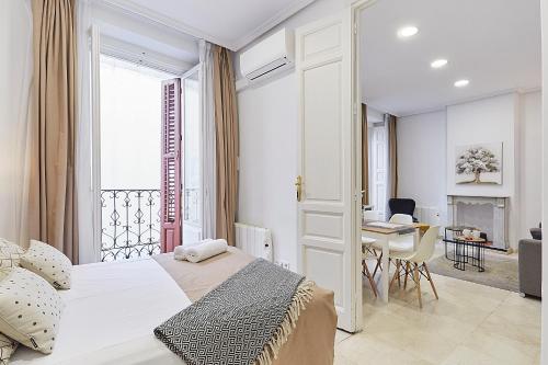 1 dormitorio con cama, mesa y ventana en LEEWAYS APARTMENT VI in GRAN VÍA, en Madrid