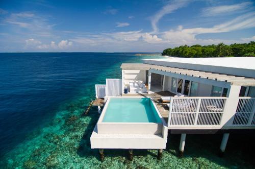 a house with a swimming pool in the ocean at Amilla Maldives in Kihaadhoo