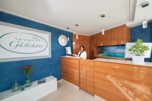 a woman standing at a counter in a salon at Victory Gästehaus Therme Erding in Erding