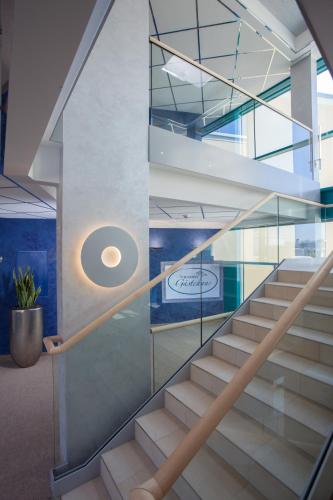 a staircase in a office building with glass railing at Victory Gästehaus Therme Erding in Erding