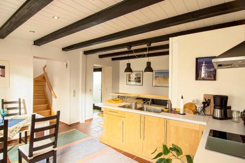 uma cozinha com armários de madeira e uma mesa num quarto em Ferienwohnung Gilg em Cuxhaven