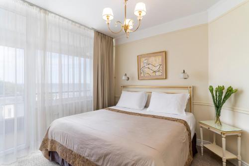 a bedroom with a bed and a large window at Baltic Beach Hotel & SPA in Jūrmala