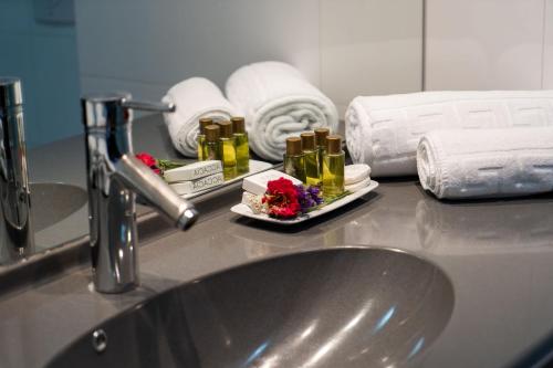 a sink in a bathroom with towels and a sink at Hotel Parliament in Bucharest