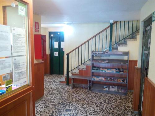 a hallway with a staircase and a book shelf at Apartaments Els Avets in Pas de la Casa