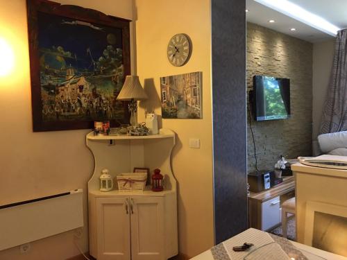 a living room with a clock on the wall at Apartment Marija- Kopaonik centar in Kopaonik