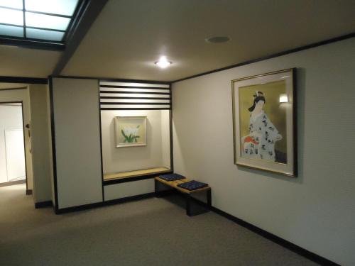 a hallway with a painting of a woman on a wall at Yamagisi Ryokan in Fujikawaguchiko