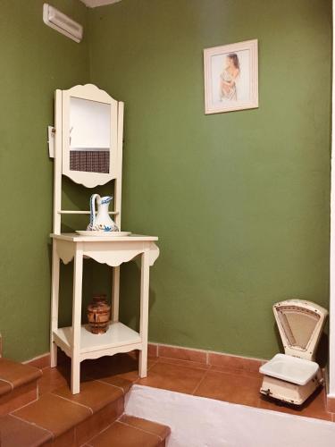 a green room with a white shelf and a mirror at La casita Santa Bárbara in Macastre