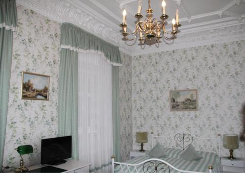 a bedroom with a bed and a chandelier at Hotel-Fink in Hamburg