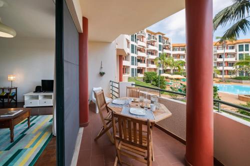 a balcony with a table and chairs and a pool at Varandas do Funchal II by An Island Apart in Funchal