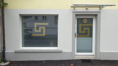 a white building with a door and a window at Grosses Apartement 2 Schlafzimmer am Bodensee in Arbon