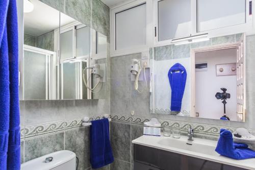 een badkamer met een wastafel en een blauw douchegordijn bij Alsol Patricio in Playa del Inglés