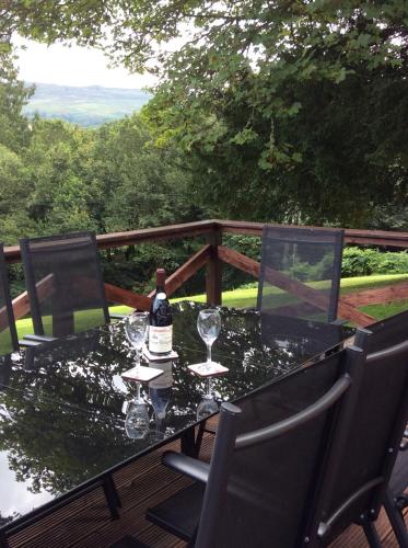 uma mesa com copos e uma garrafa de vinho em Brandoch Lodge em Logierait