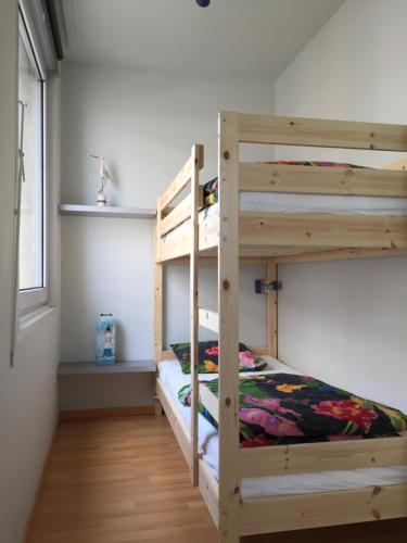 1 dormitorio con 2 literas y ventana en Rustig, kindvriendelijk appartement, en Ostende