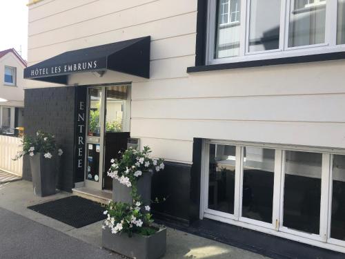 a store front with two potted plants in front of it at Hotel Les Embruns in Le Touquet-Paris-Plage