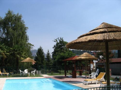 a swimming pool with umbrellas and chairs and a table at Villa Bon Repos in Argelès-Gazost