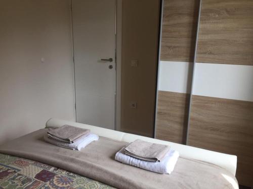 two towels sitting on a bed in front of a mirror at Apartment Luiza Funtana in Funtana