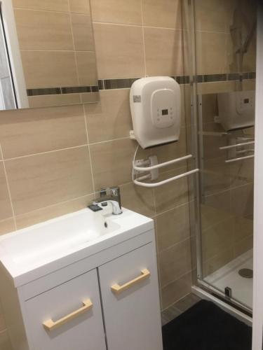ein Badezimmer mit einem weißen Waschbecken und einer Dusche in der Unterkunft le studio de Molière in Montluçon