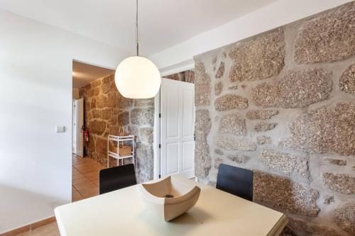 a dining room with a stone wall at Eido do Carvalhoso - Casa de Campo em Arcos de Valdevez in Arcos de Valdevez