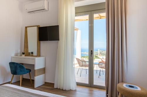 a bedroom with a room with a view of the ocean at Kallixeni Villas in Rethymno Town