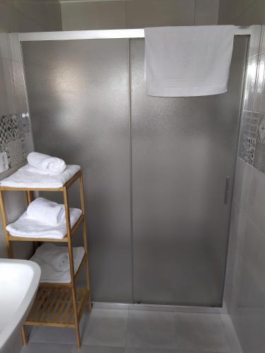 a bathroom with a shower and a shelf with towels at Penzion a restaurace U Kalendů in Strážnice