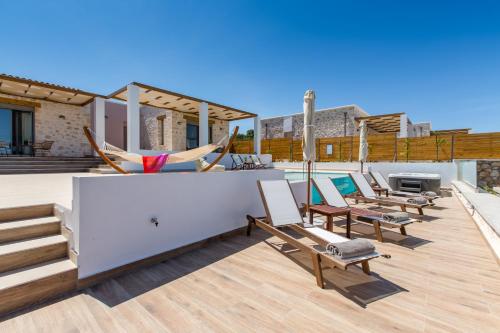 a deck with chairs and a hammock on a house at Kallixeni Villas in Rethymno Town