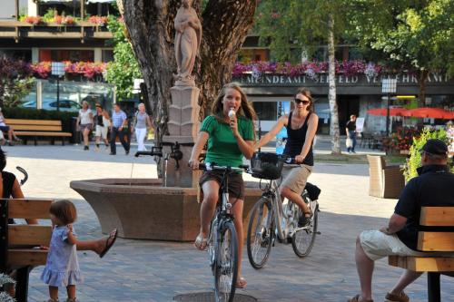two women riding bikes near a fountain in a city at A-VITA Viktoria & A-VITA living luxury apartments in Seefeld in Tirol