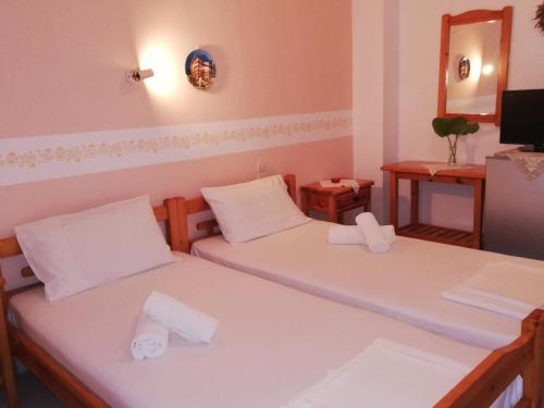 two beds in a small room with a mirror at Villa Horizon in Tsagarada