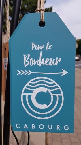 a sign for a donut shop hanging from a pole at Port-Guillaume, résidence de vacances avec mer & piscine in Dives-sur-Mer