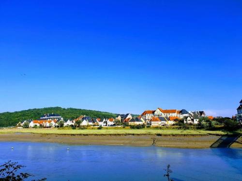 a group of houses on the shore of a body of water at Port-Guillaume, résidence de vacances avec mer & piscine in Dives-sur-Mer
