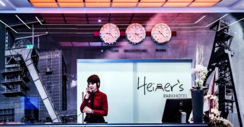 a woman standing in front of a store with clocks on it at Heiner's Parkhotel in Gelsenkirchen