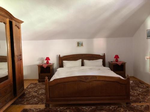 a bedroom with a bed with two end tables at Casa Ani in Borşa