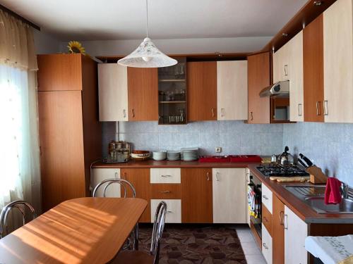 a kitchen with wooden cabinets and a table in it at Casa Ani in Borşa