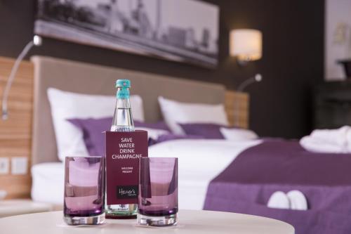 a bottle and two glasses on a table in a hotel room at Heiner's Parkhotel in Gelsenkirchen