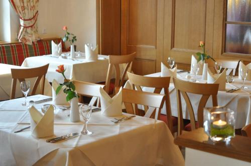 a group of tables with white table linen and flowers on them at Hotel Gasthof Engel in Appenweier