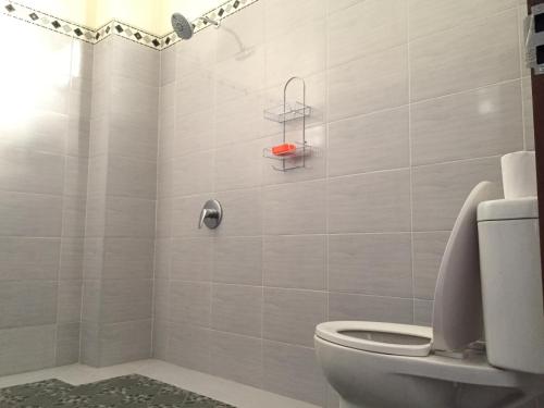 a bathroom with a toilet and a shower at Purnama 2 Homestay in Canggu