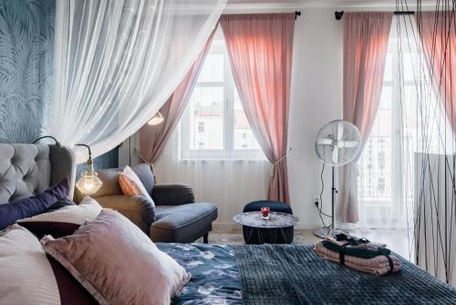 Romantic designer apartment Prague في براغ: غرفة معيشة مع سرير وأريكة