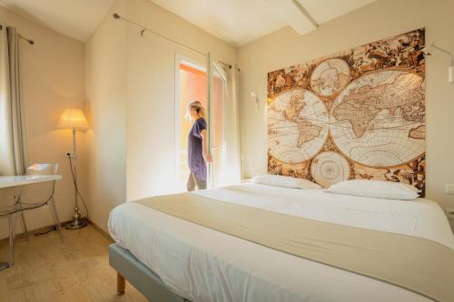une femme debout dans une chambre donnant par la fenêtre dans l'établissement Hotel Grand Cap Rooftop Pool, à Agde