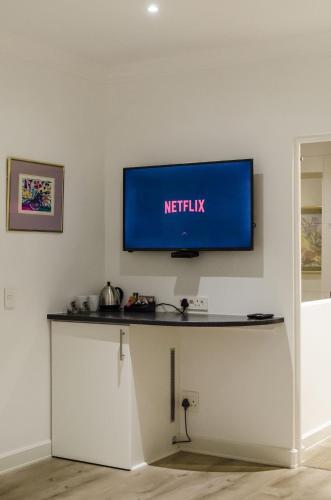 a flat screen tv on a wall in a room at Somerset View Guest House in Somerset West