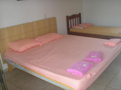 a bed with pink sheets and pink towels on it at Park Golf Hostel Ipelandia in Foz do Iguaçu