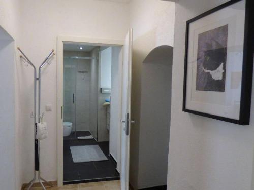 a bathroom with a toilet and a picture on the wall at Pirna-Apartment in Pirna